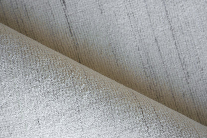 Beige hand-loomed rug with woven texture and soft folds, 12' x 15'.