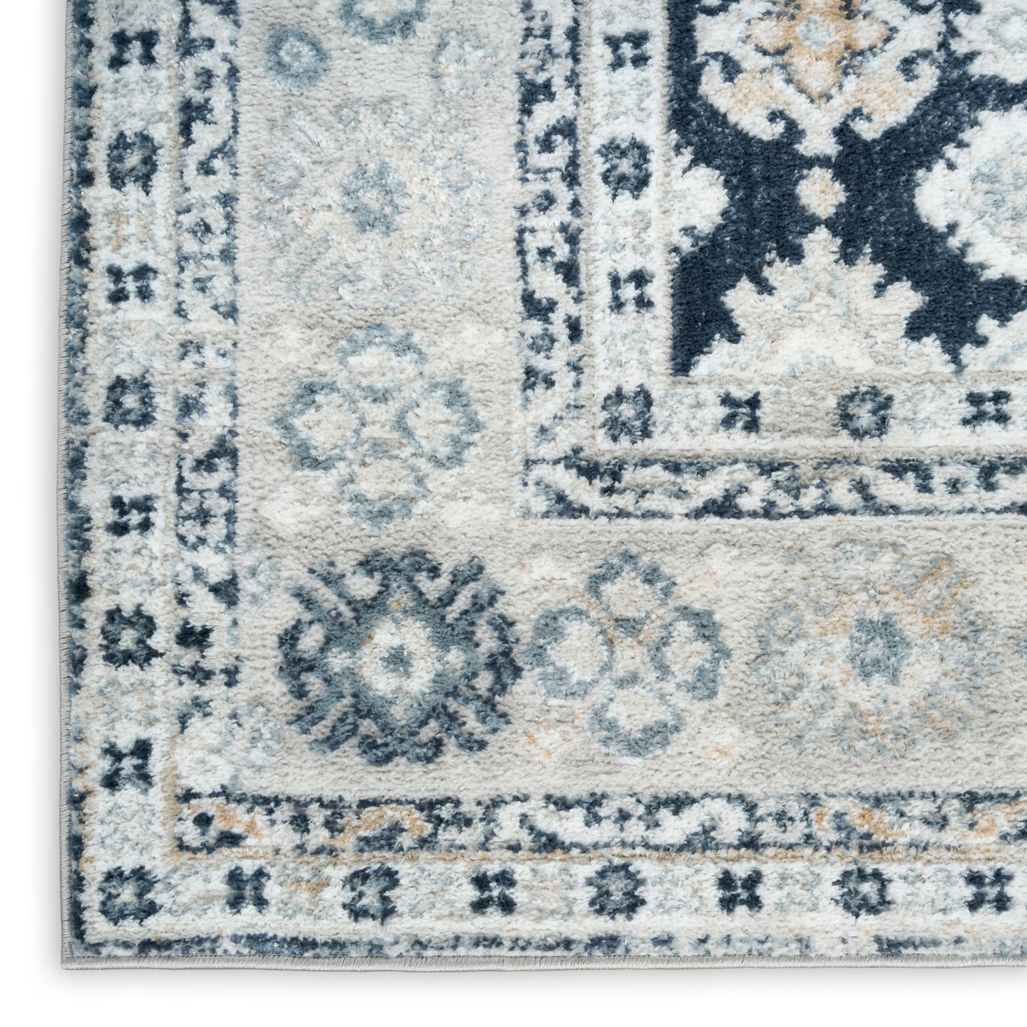 Close-up of a plush blue-gray oriental rug with ivory border, floral medallions and navy accents.
