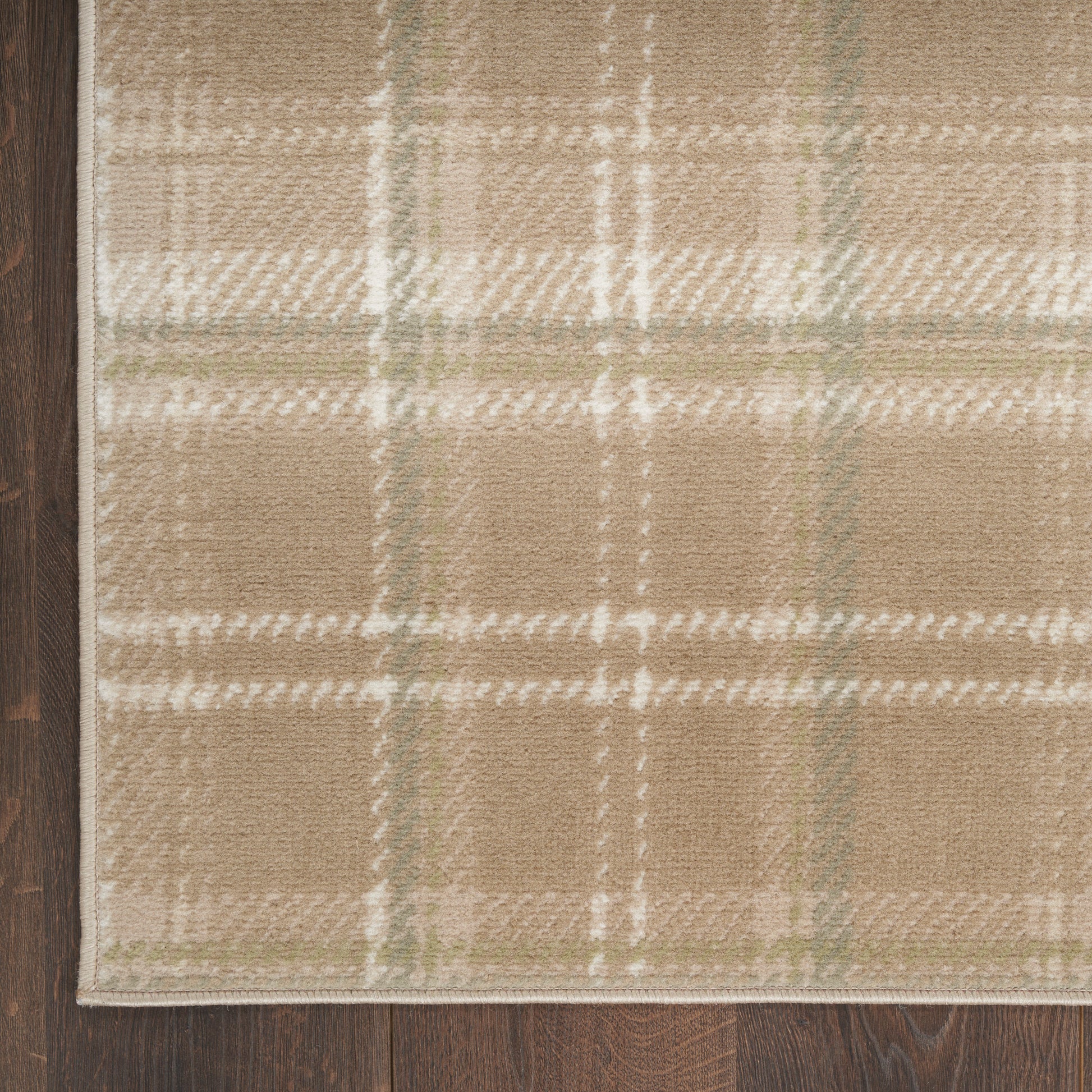 Beige plaid rug with pale green lines and a light border on dark wood floor, 3' x 5'.