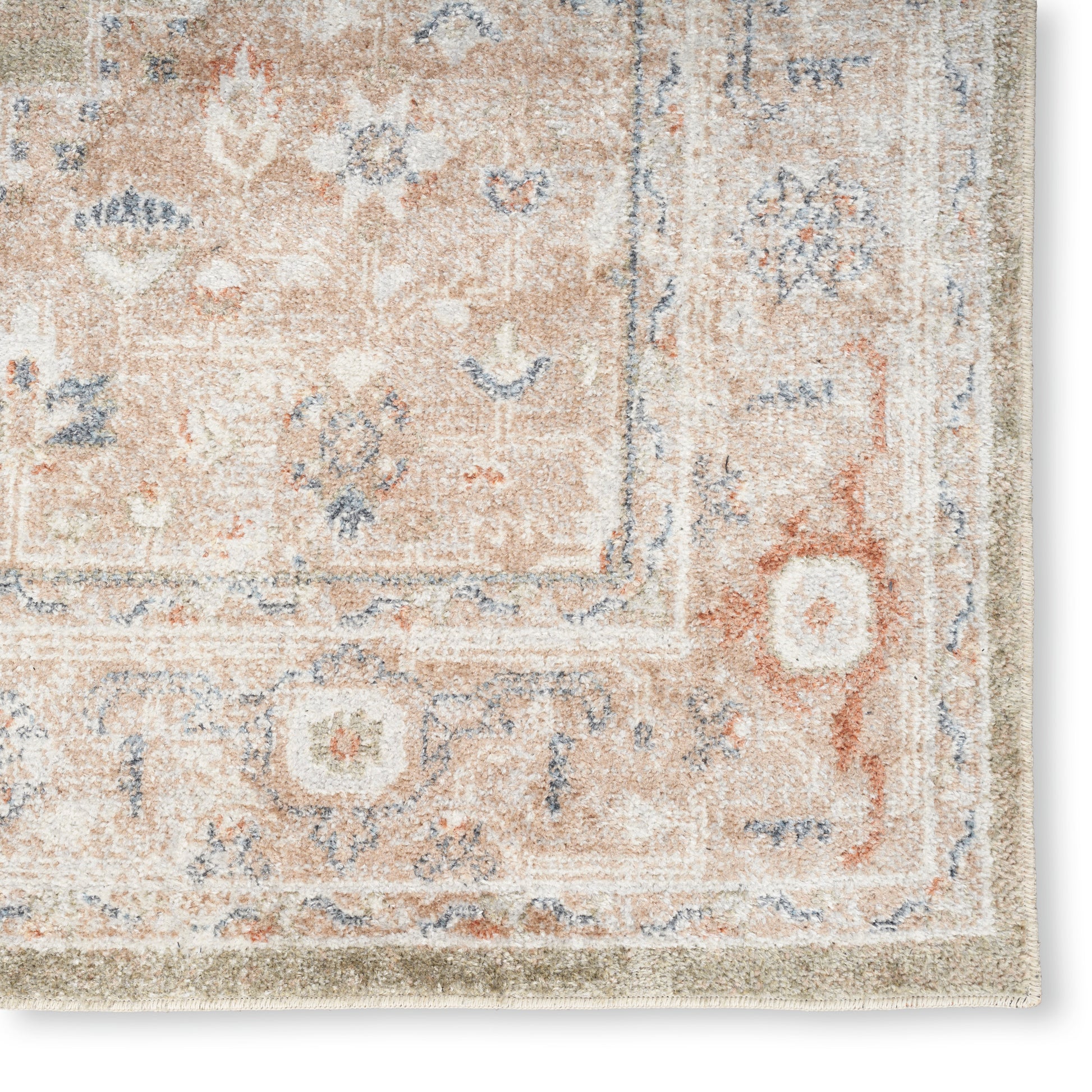 Close-up of a peach and ivory traditional Persian-style area rug with blue floral motifs and decorative border.