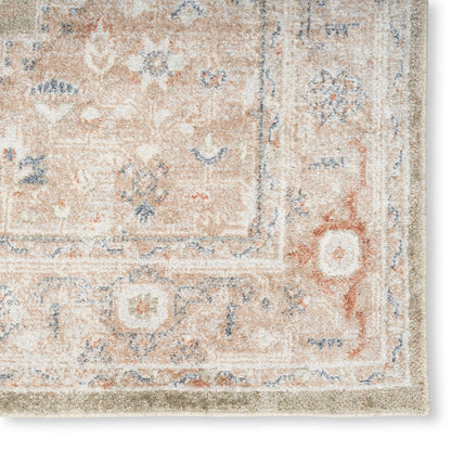 Close-up of a peach and ivory traditional Persian-style area rug with blue floral motifs and decorative border.