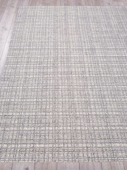 Rectangular gray hand loomed indoor area rug with a subtle grid pattern on a light wood floor.