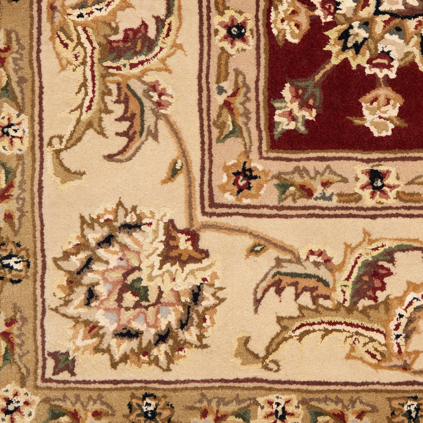 Ornate oriental rug close-up: ivory field with scrolling floral motifs and a burgundy inner panel framed by layered borders.
