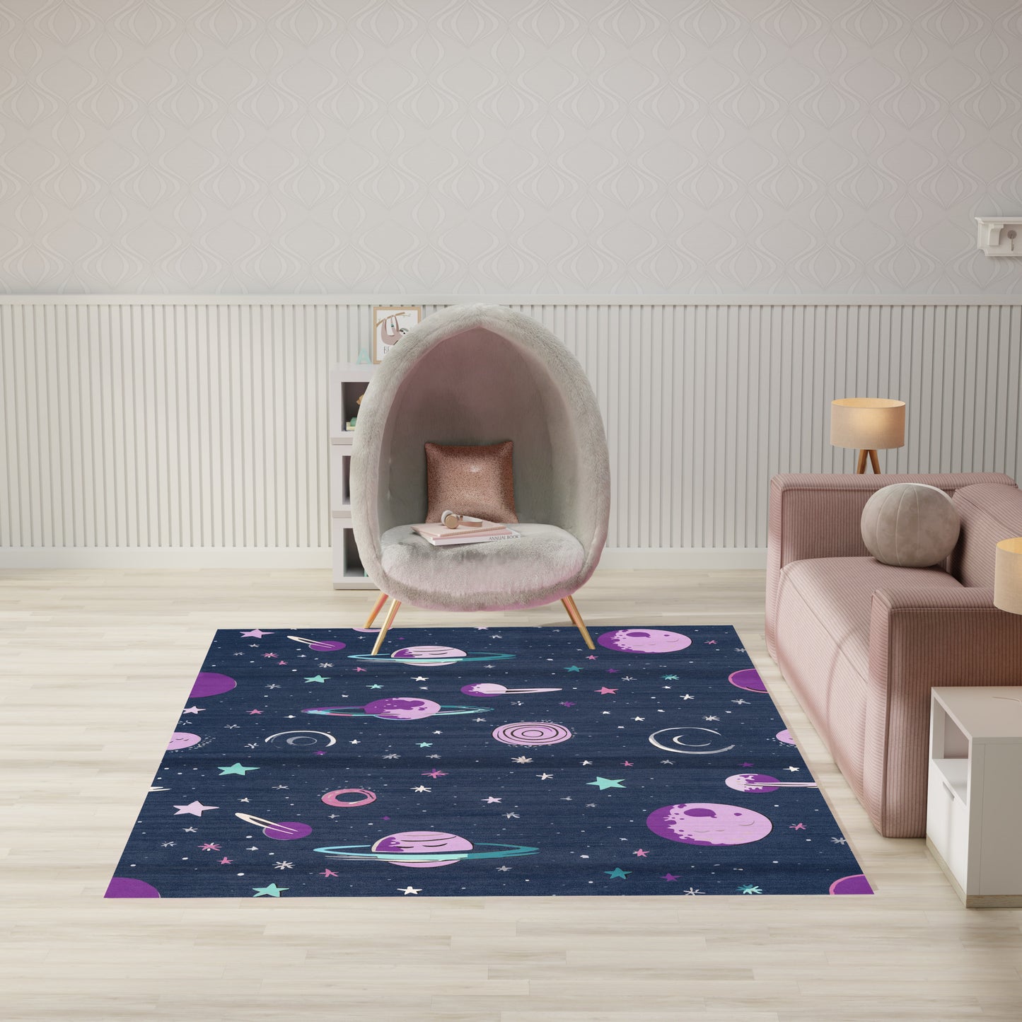 Living room with navy space rug featuring planets and stars, a gray pod chair with pink cushion, and a blush pink sofa.