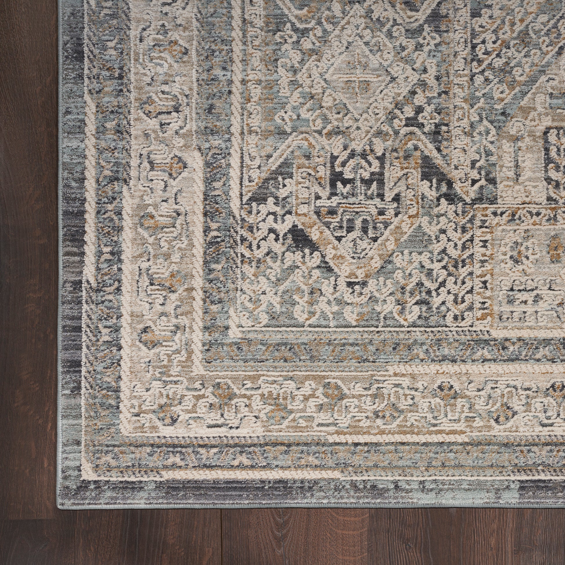 Traditional blue and ivory Oriental runner with geometric medallion, distressed pattern on dark wood floor.