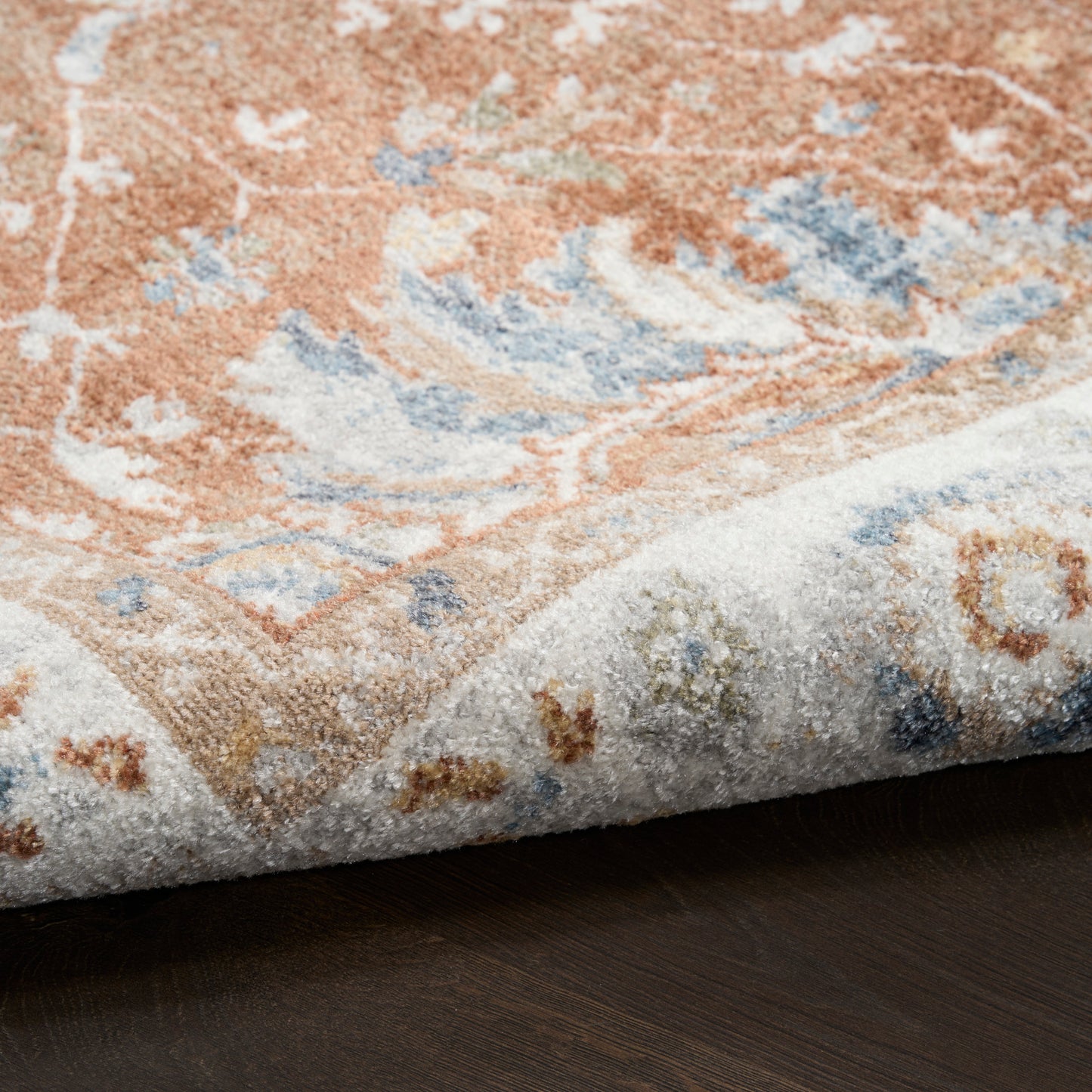 Persian-style rug with orange, blue and ivory floral pattern; plush pile for living room decor.
