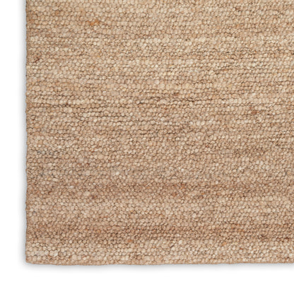 Beige loop-pile rug close-up, plush textured surface in warm tan tones.