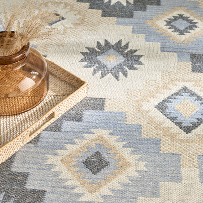 Blue and beige geometric kilim rug with diamond motifs, 5' x 7'.