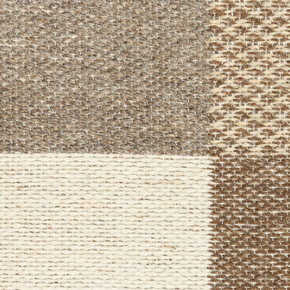 Rectangular patchwork rug with beige, cream & brown woven panels; textured natural-fiber look.