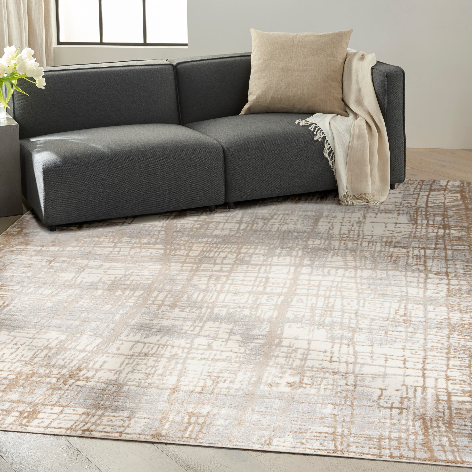 Dark gray modern rug with a neutral abstract pattern, 7' x 10', in a contemporary living room.