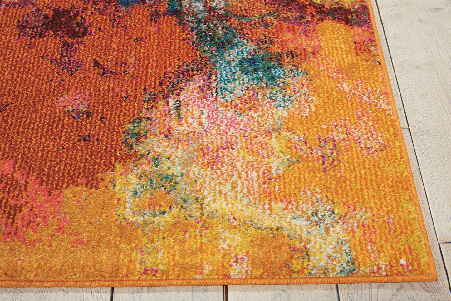 Vibrant orange abstract area rug with teal, pink and yellow accents, orange border, on light wooden floor.