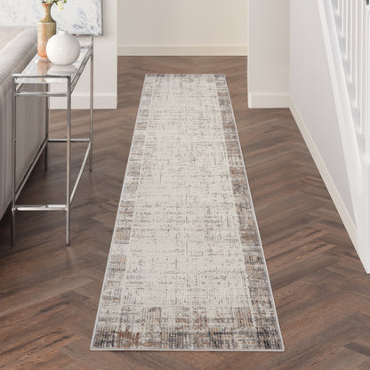 Neutral distressed runner rug in beige and taupe on herringbone hallway floor with a console table.