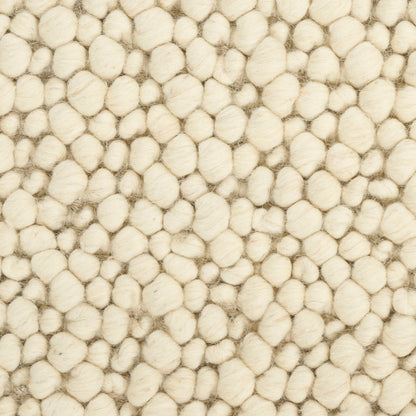 Cream boucle wool rug texture with densely packed round tufts, soft and cozy.