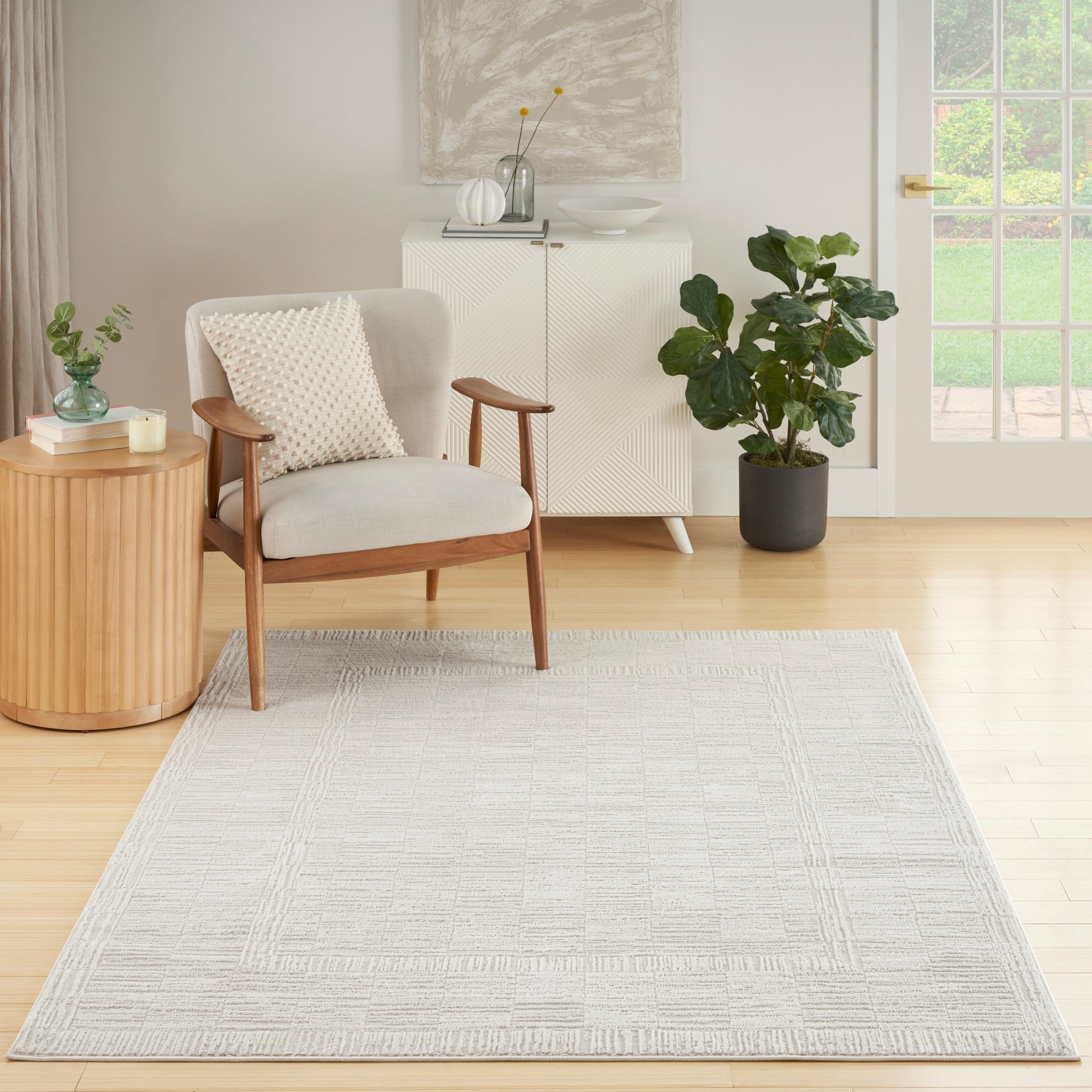 Light gray textured area rug with a geometric border, perfect for a modern mid-century living room.