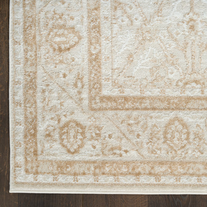 Beige ornate area rug with cream and tan border pattern, textured pile in a Persian-inspired design on dark wooden floor.