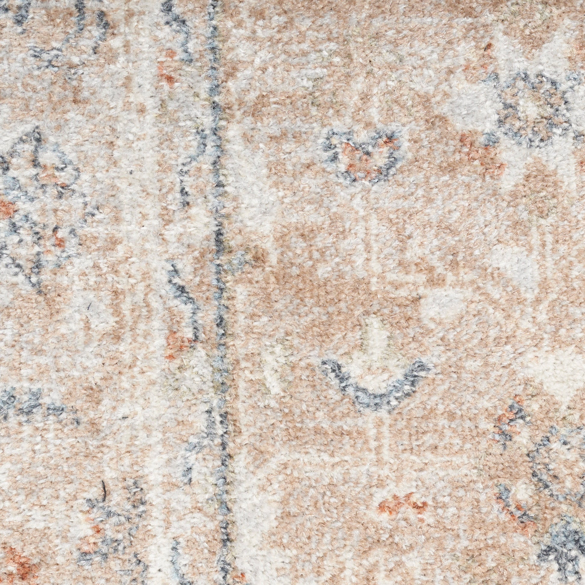 Close-up of a beige vintage-style round rug with blue and orange floral motifs and a soft textured pile.