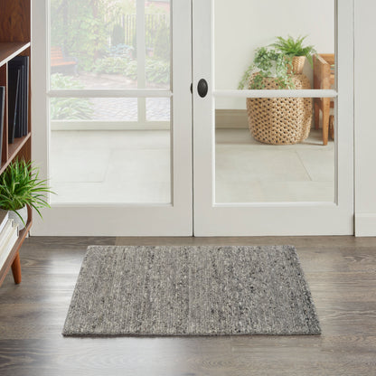 Rectangular gray textured entry rug on dark wood floor in front of white-framed French doors.