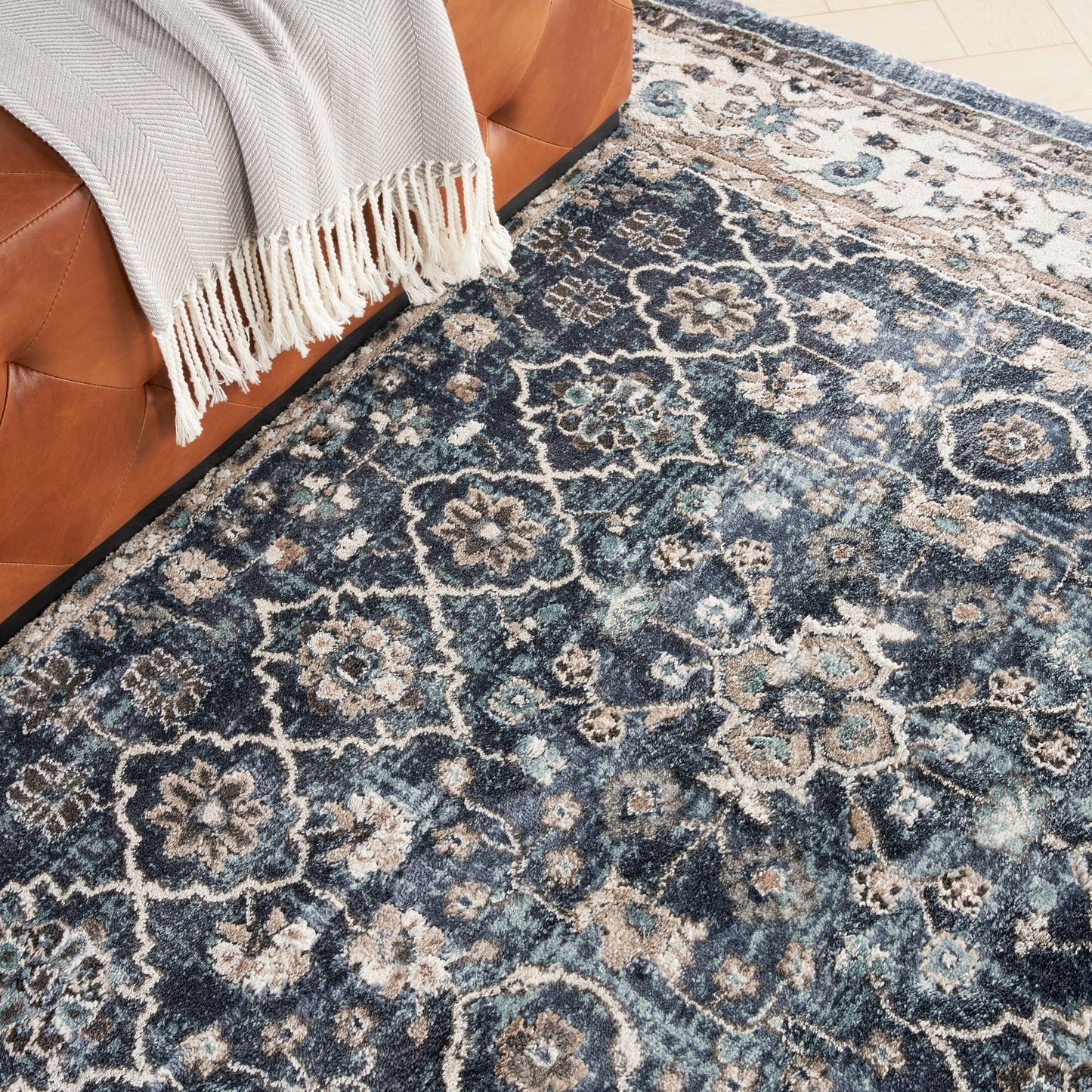 Blue distressed floral medallion area rug with ivory accents; traditional living room style.