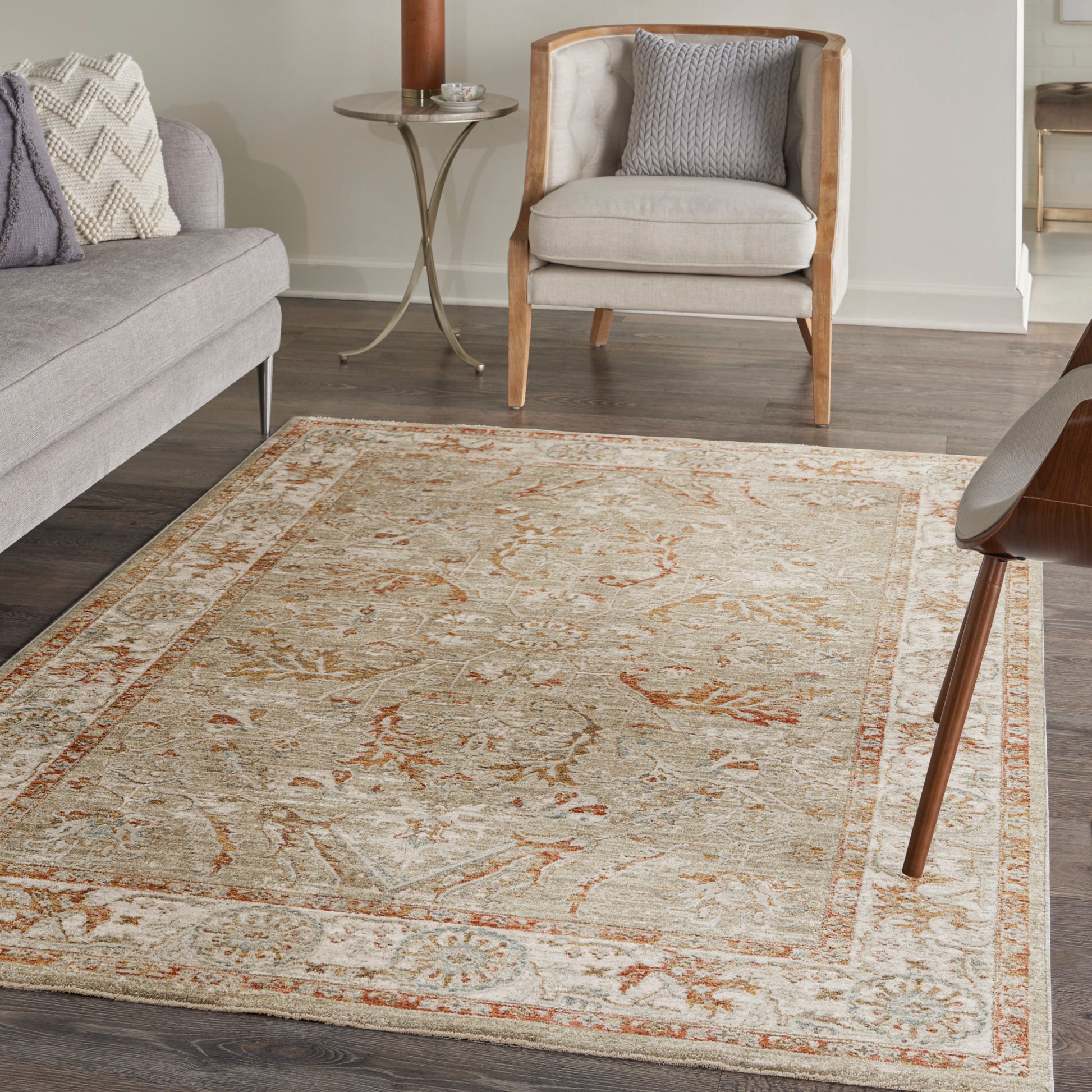 Cream oriental area rug with warm orange floral motifs and blue accents, soft pile in a modern living room.