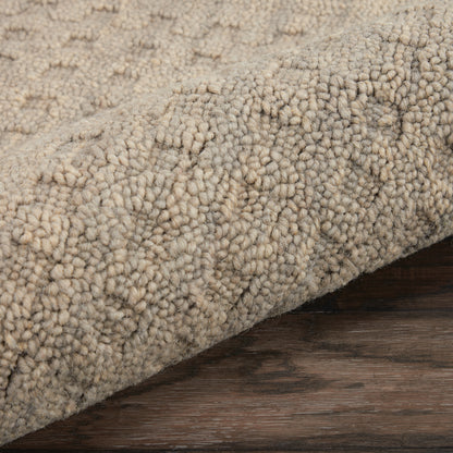 Beige boucle shag rug with chunky textured pile rolled on dark wood floor.