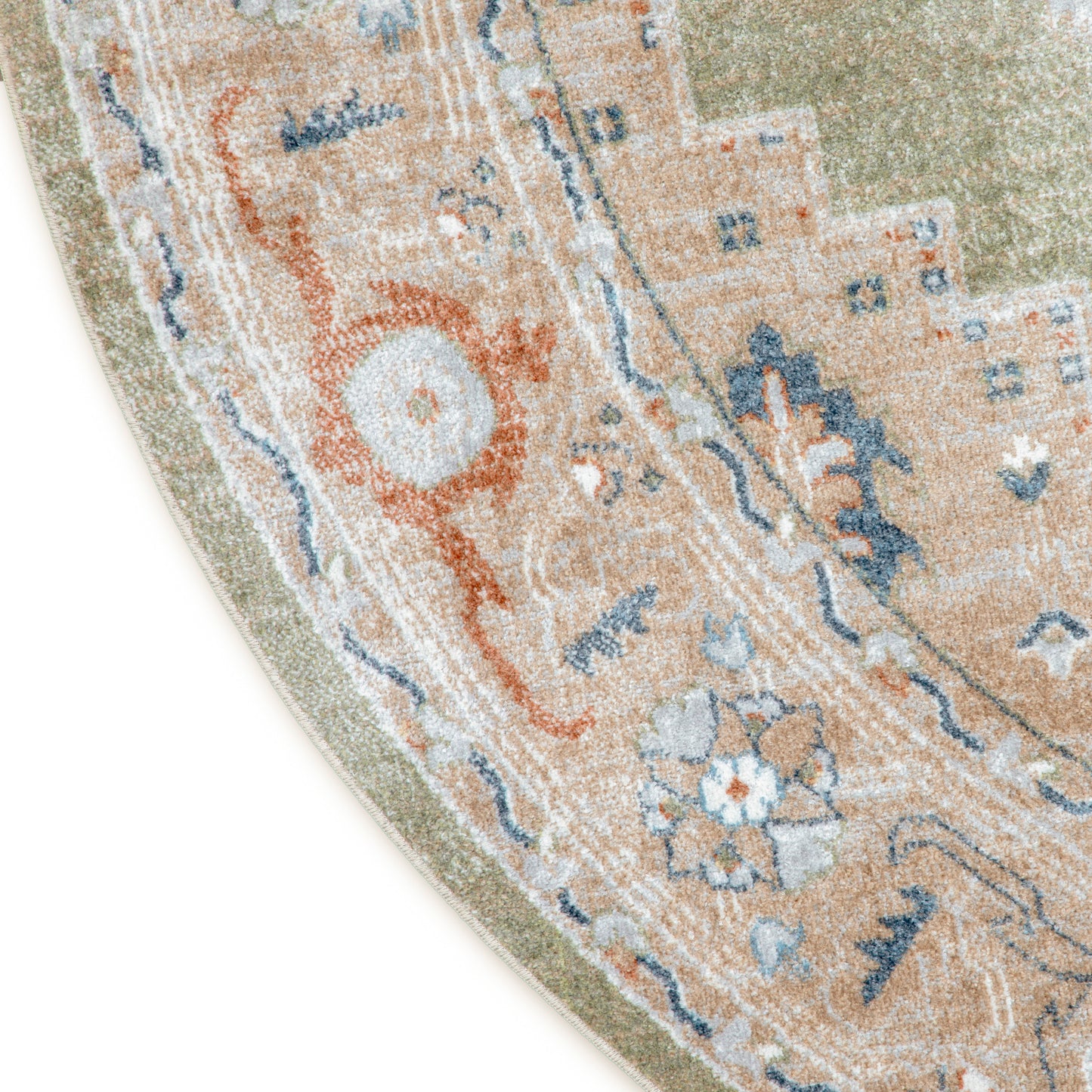 Partial view of round oriental rug: peach-beige field with blue and orange floral motifs and sage-green border.