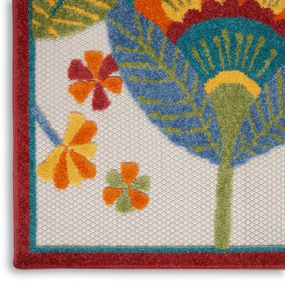 Colorful woven tropical rug with a red border, teal edging, and orange-yellow floral and green palm leaf motifs on a white background.