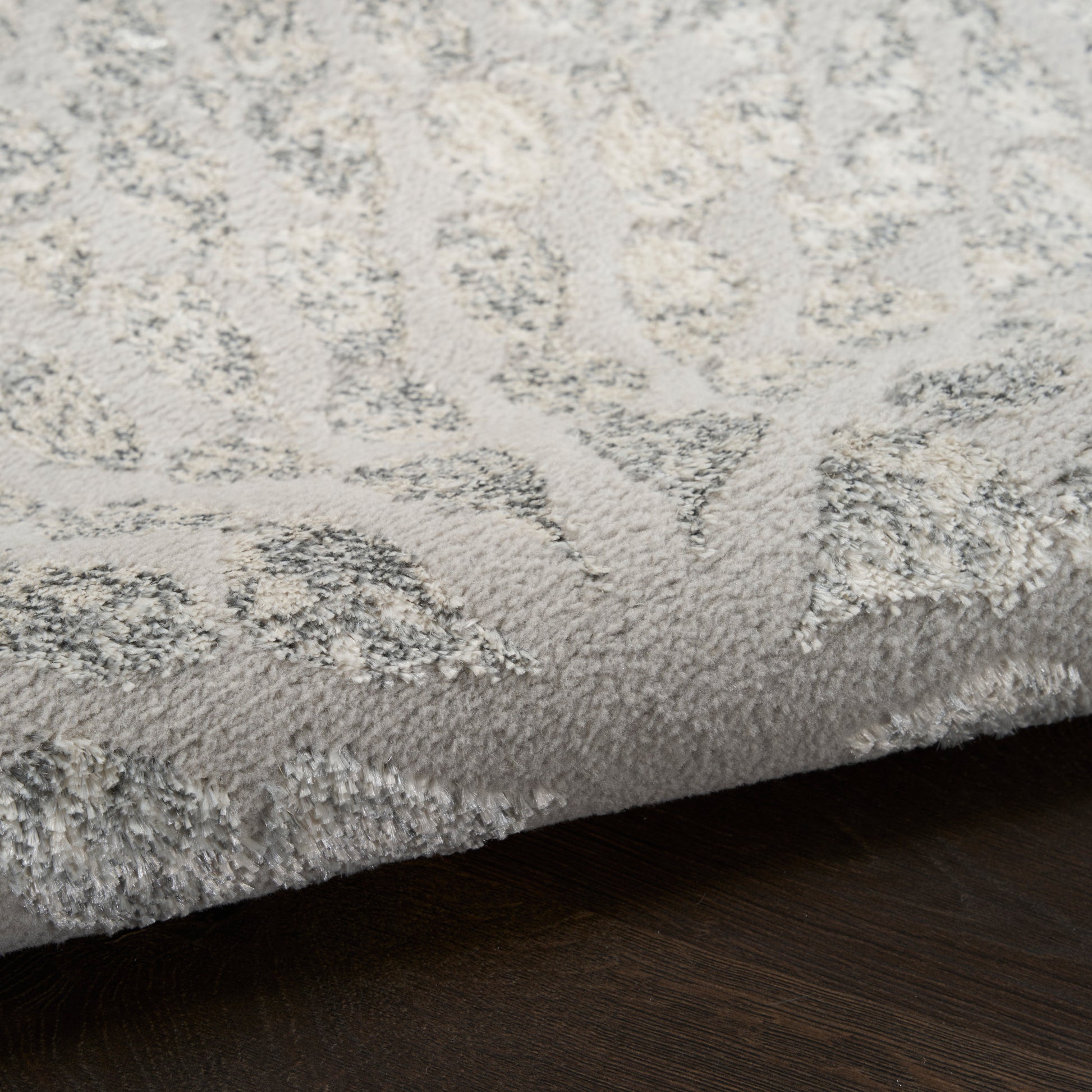 Light gray plush rug with a subtle raised pattern and soft, dense pile.