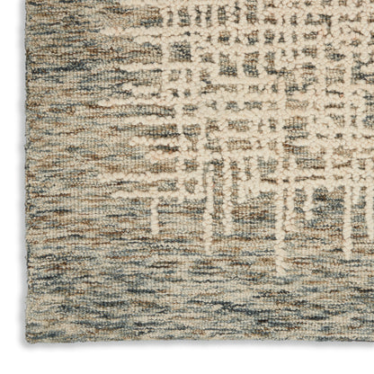 Close-up of a rectangular textured rug in cream, beige & blue-gray with an abstract geometric pattern and loop pile.