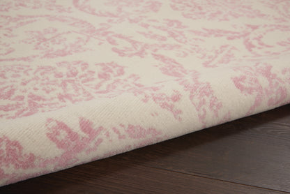 Cream rug with pink damask pattern, soft woven textile on dark wood floor.