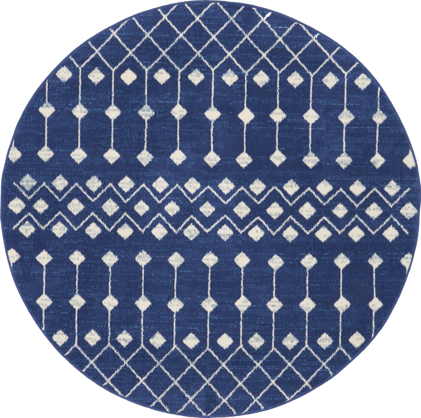 Round navy-blue rug with white geometric lattice and diamond motifs; modern coastal/boho style.
