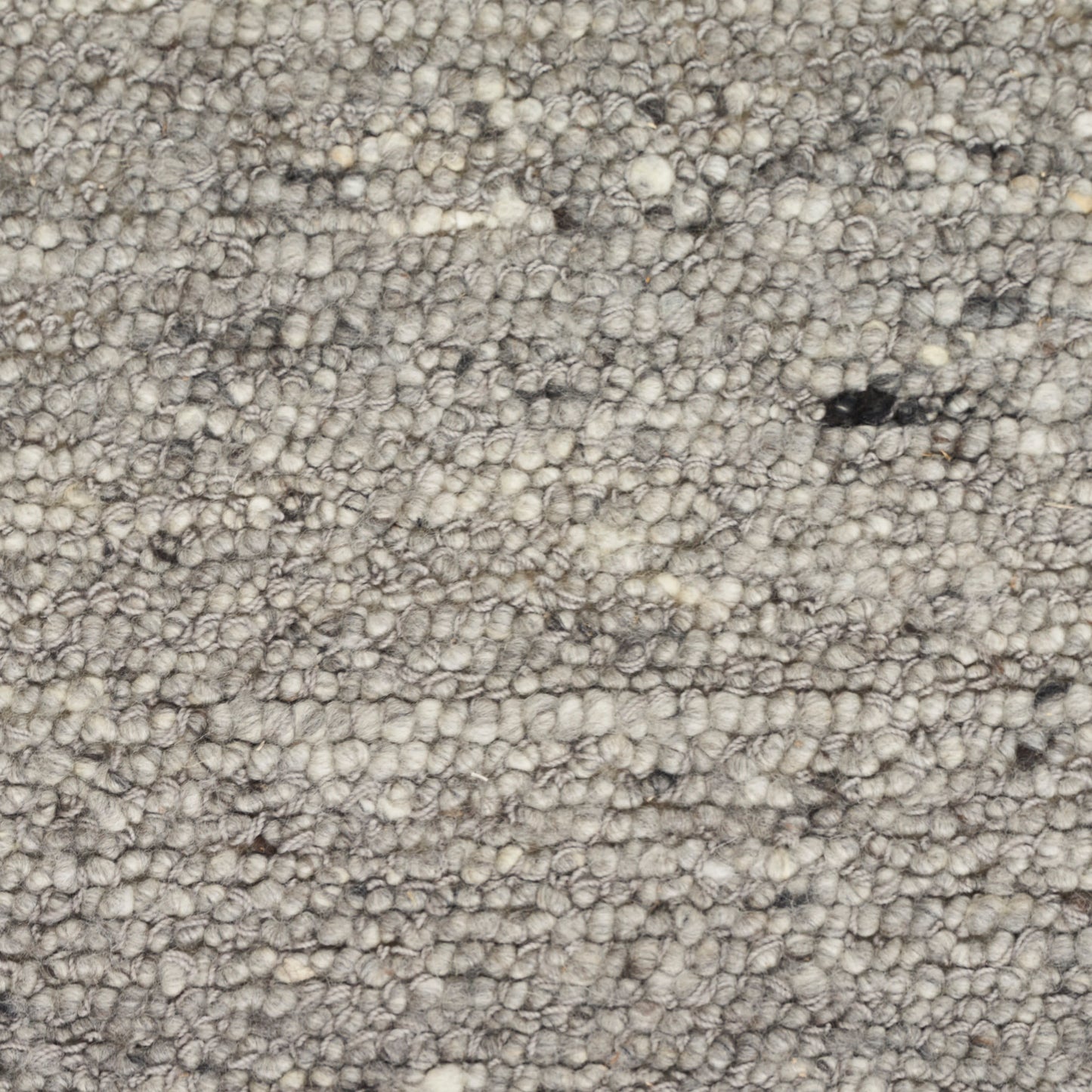Neutral gray-beige looped-pile rug close-up with dense textured tufts.