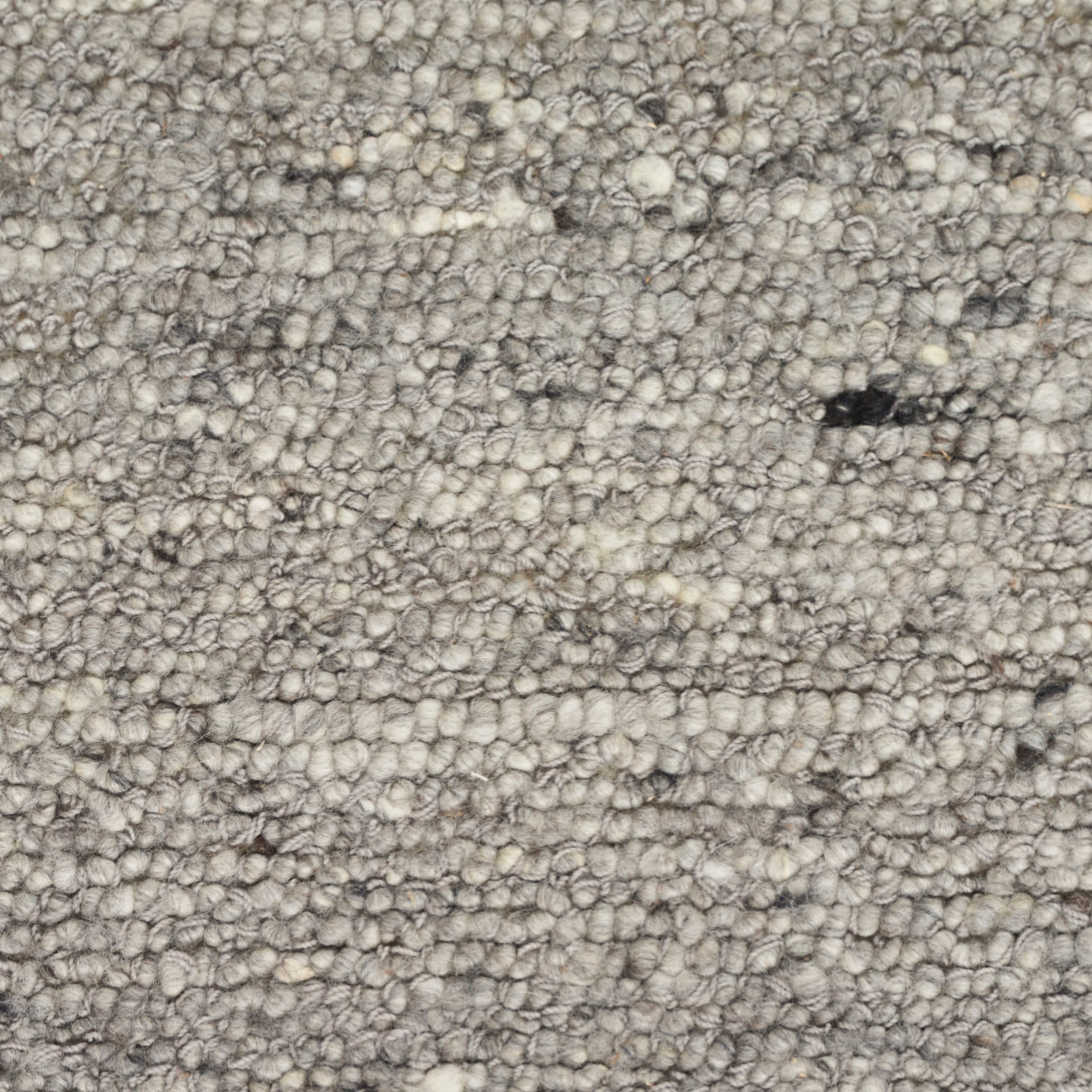 Neutral gray-beige looped-pile rug close-up with dense textured tufts.