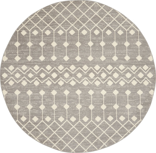 Round taupe rug with cream geometric lattice diamonds and chevron bands.