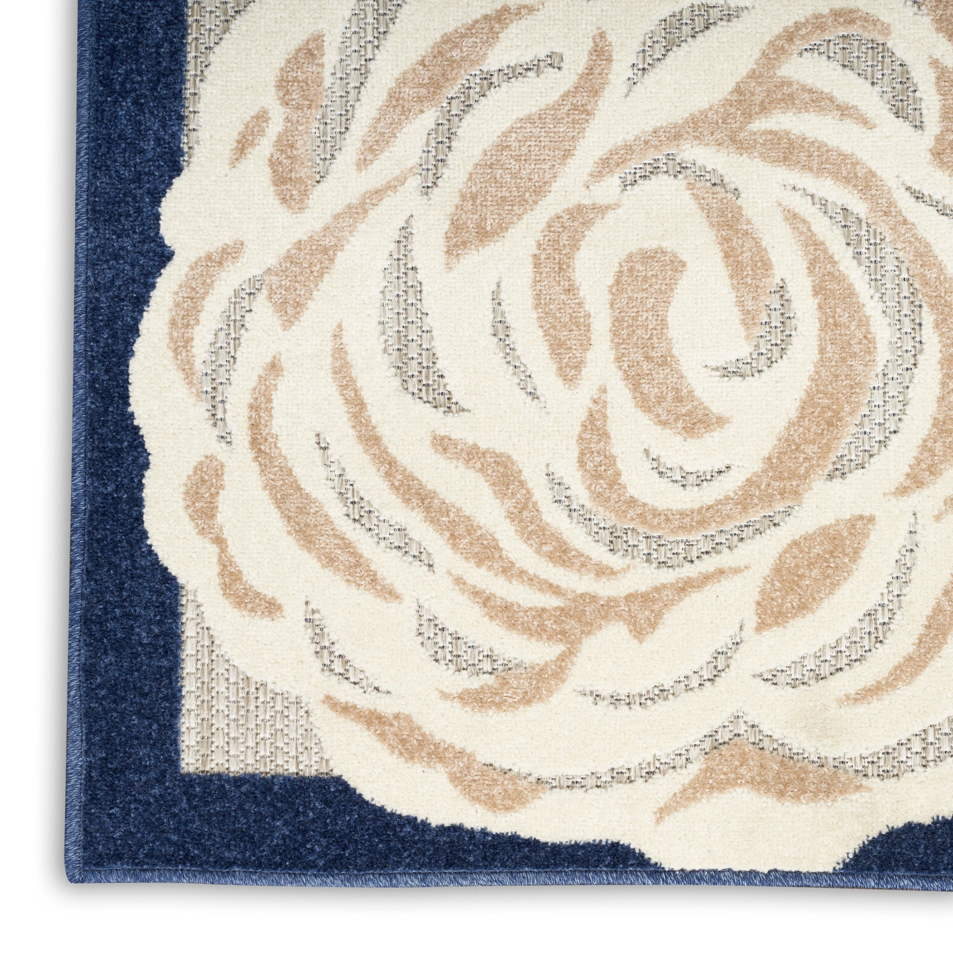 Close-up of a woven rug featuring a cream rose motif on beige with a dark blue border.