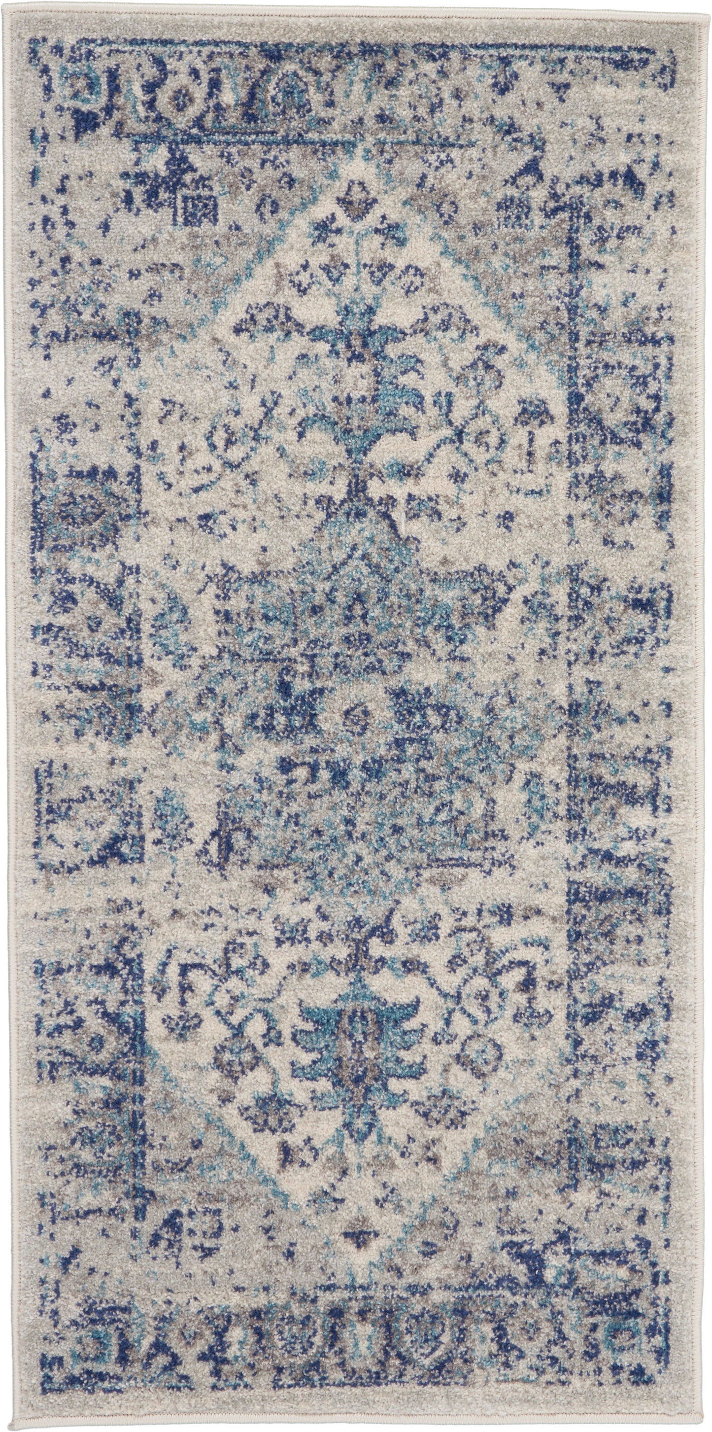 Rectangular blue-and-ivory distressed oriental rug with central medallion and floral motifs.