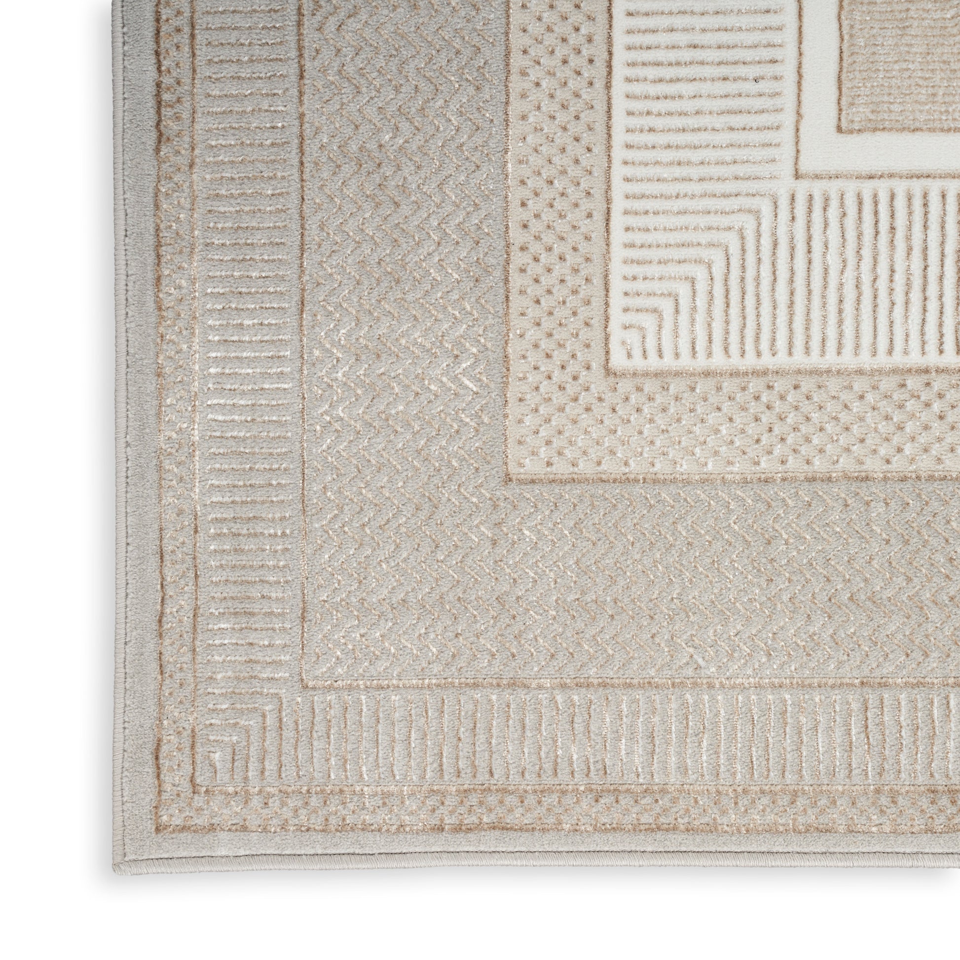 Beige textured area rug with layered borders and geometric patterns in tan and ivory tones.