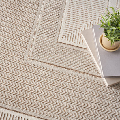 Beige woven rug with chevron and geometric textures, magazines stacked and a small potted plant on top.