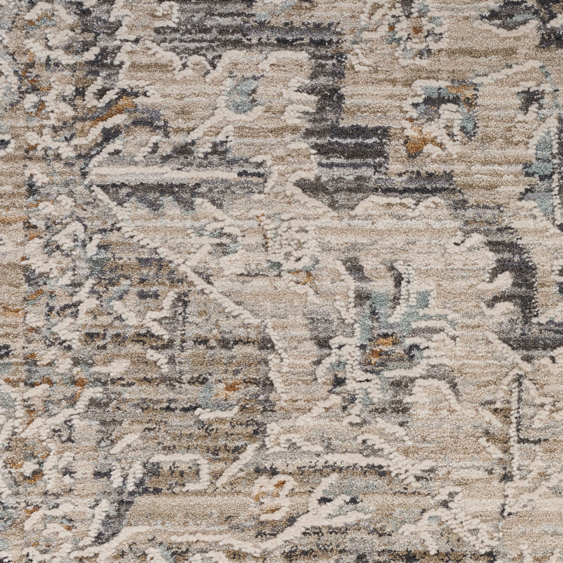 Muted beige distressed area rug with gray-blue accents and subtle floral motifs; soft woven texture.