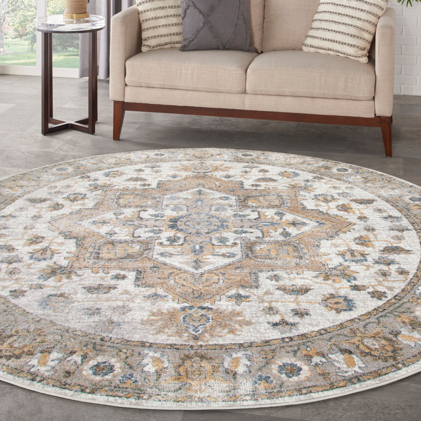 Round vintage-style area rug with ornate medallion in beige, ivory, gray & pale blue; plush low-pile in living room.