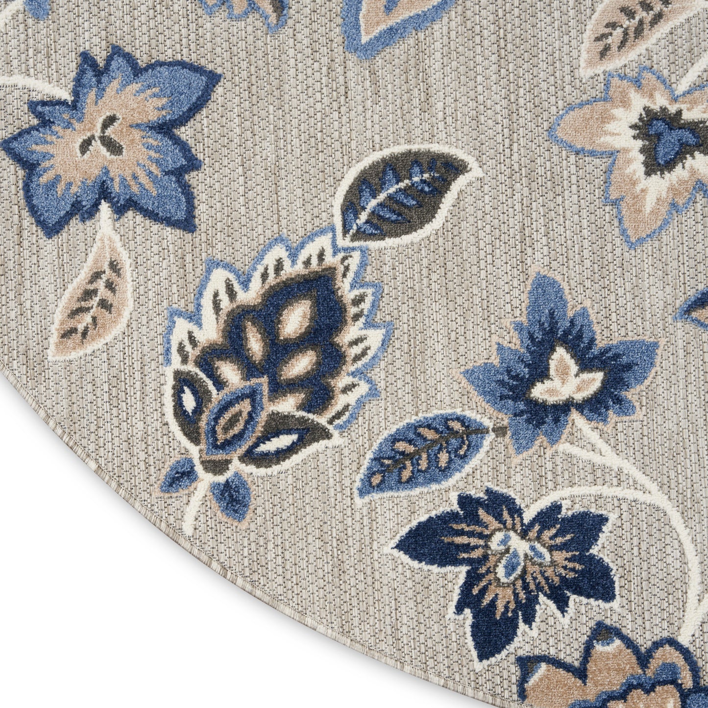 Beige woven area rug with blue floral pattern; navy and sky-blue flowers and leaves in a botanical design.