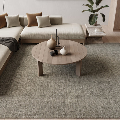 Vintage 5' x 8' rug with a textured taupe pattern in a living room, with a neutral sectional sofa visible.