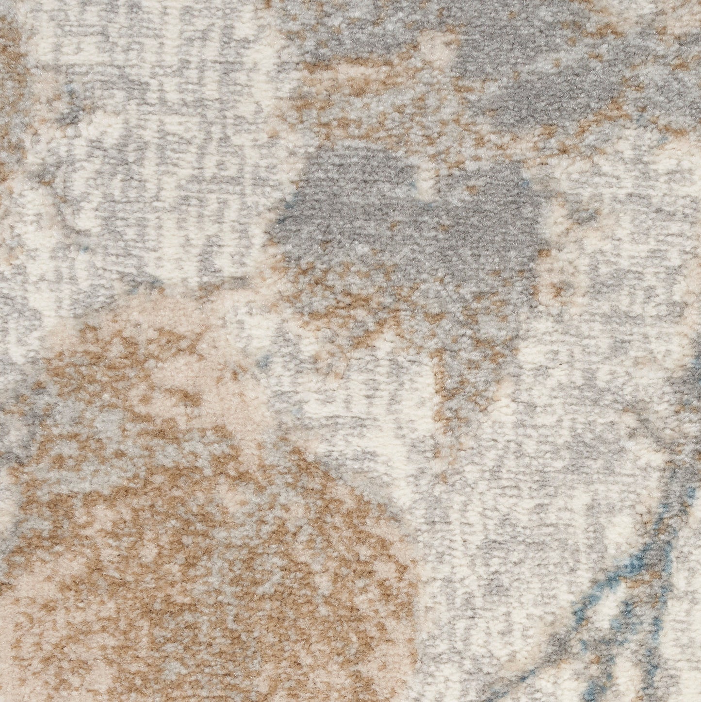 Close-up of a textured abstract area rug in beige, taupe, gray and pale blue with a soft plush pile.