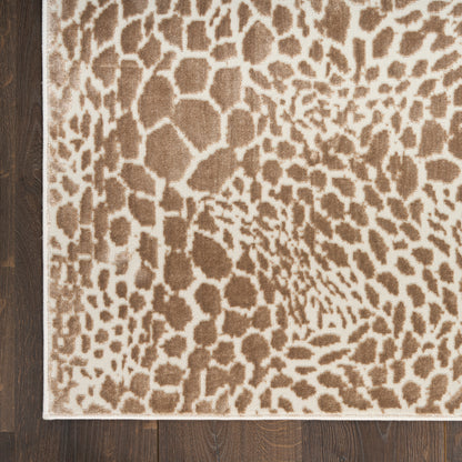 Beige leopard-print area rug with brown spots and light border on dark wood floor.