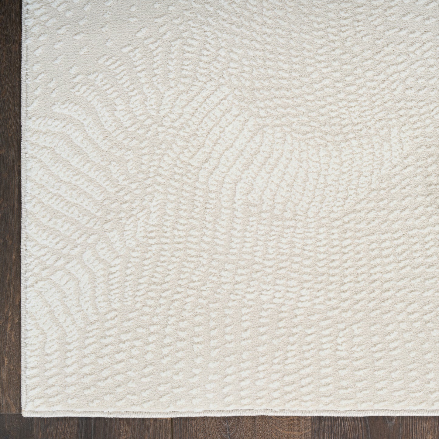 Ivory textured area rug with raised swirl pattern and plush loop pile, modern cozy living room decor.