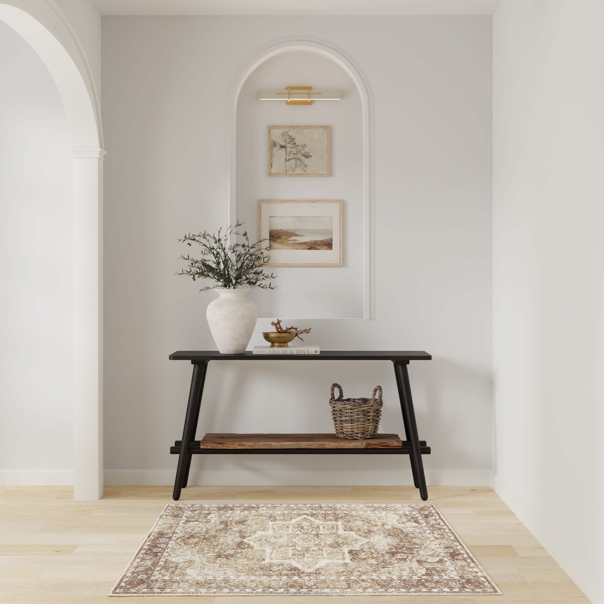 Black two-tier console table with vase of greenery and a basket, set in an arched alcove with framed art and a beige rug.