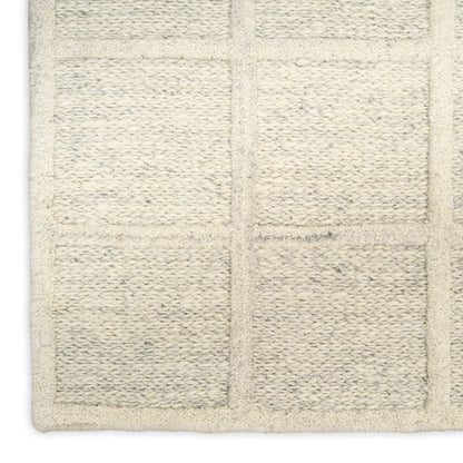 Cream area rug with a square grid pattern and plush, looped pile.