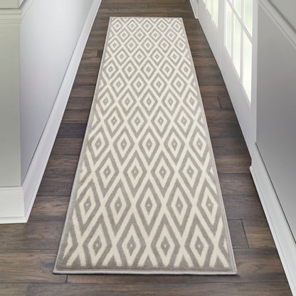 Long hallway runner rug with light gray and white diamond geometric pattern on dark wood floor.