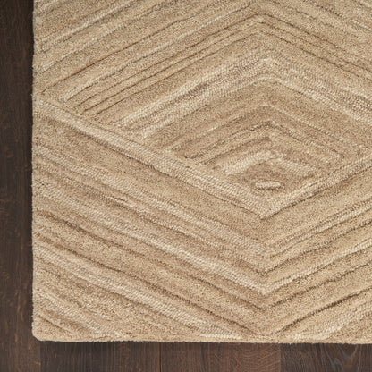 Beige textured pile rug with diamond chevron pattern on dark wood floor.