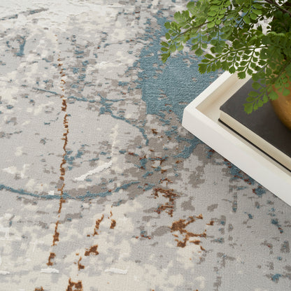 Woven abstract area rug in beige with blue, gray and brown accents; modern living-room decor.