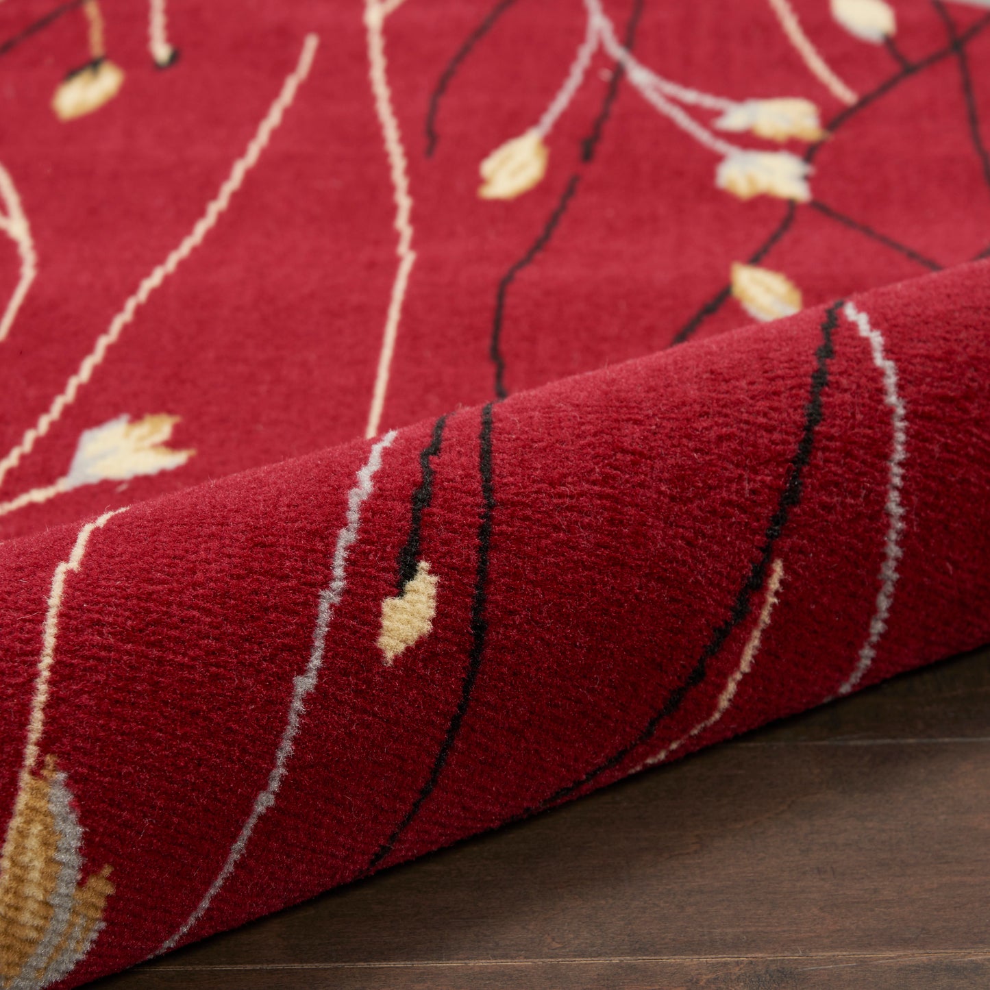 Red plush round rug, 5' diameter, with white and beige leaf-like motifs and black lines; modern textured decor.